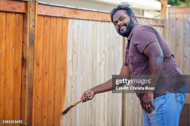 east indian staining a fence - christa stock pictures, royalty-free photos & images