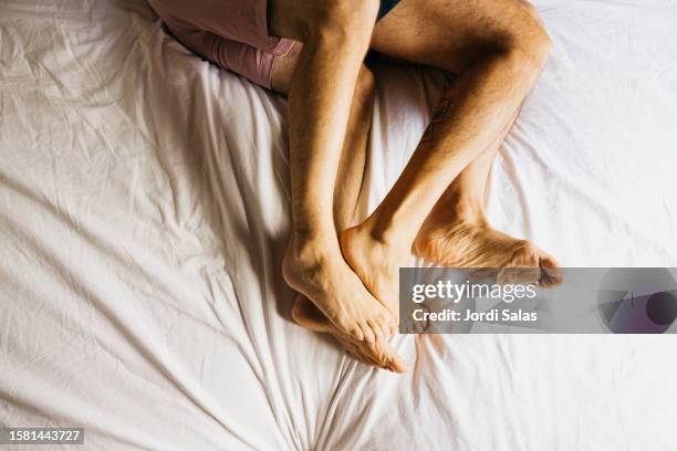 feet of affectionate gay couple bonding in bed. - sexual issues stock pictures, royalty-free photos & images