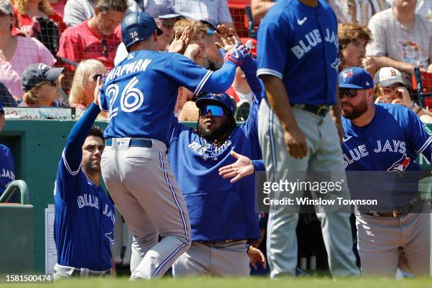 Vladimir Guerrero Jr. #27 of the Toronto Blue Jays, center, greets Matt Chapman after he scored against the Boston Red Sox during the third inning at...