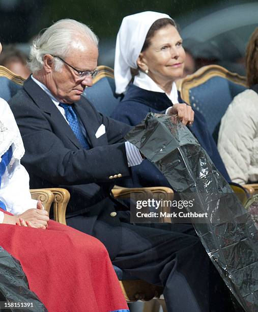 King Carl Xvi Gustaf Of Sweden And Queen Silvia Of Sweden Use Binliners To Keep Themselves Dry During Princess Victoria Of Sweden'S 34Th Birthday...