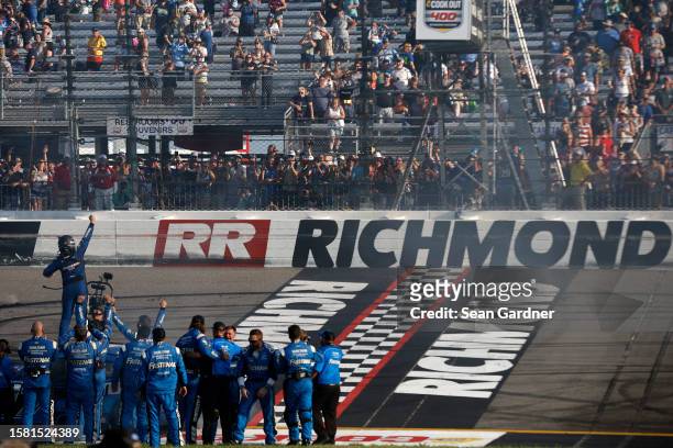 Chris Buescher, driver of the Fastenal Ford, and crew celebrate after winning the NASCAR Cup Series Cook Out 400 at Richmond Raceway on July 30, 2023...
