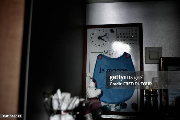 Picture taken 23 January 2007 in the kitchen of Elize in Lille, northern France showing a bib placed on a memo board with the statement "I eat,...