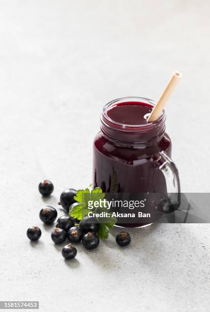 black currant drink, smoothie in a glass jar with a bamboo straw. light grey background - casis fotografías e imágenes de stock