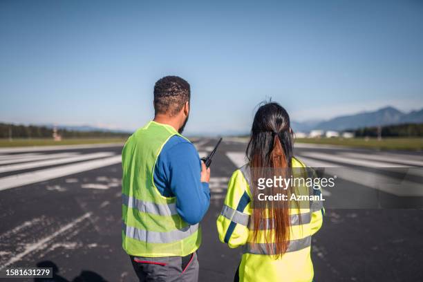 male and female airfield operation officers monitoring and maintain flight records - airport ground crew uniform stock pictures, royalty-free photos & images