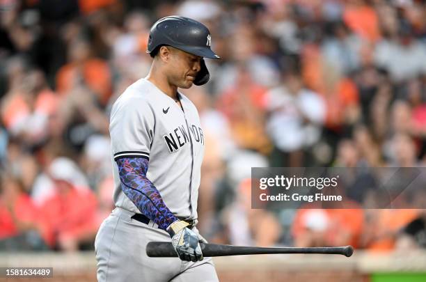 Giancarlo Stanton of the New York Yankees walks to the dugout after striking out in the third inning against the Baltimore Orioles at Oriole Park at...