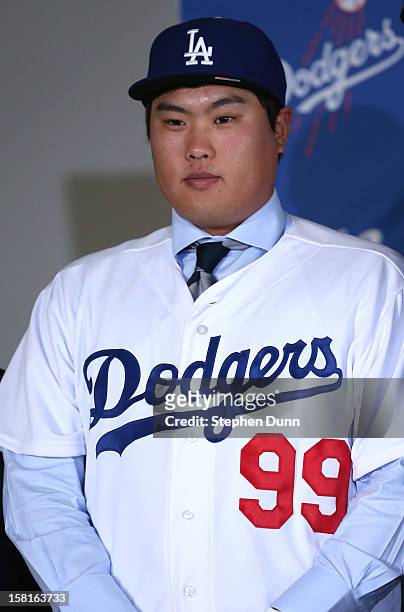 Hyun-Jin Ryu stands in his cap and jersey at a press conference introducing him following his signing with the Los Angeles Dodgers at Dodger Stadium...