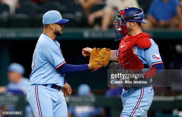 Martin Perez of the Texas Rangers celebrates with teammate Mitch Garver after the Rangers 6-0 win over the Miami Marlins at Globe Life Field on...