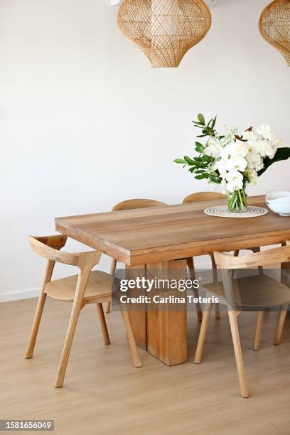 beautiful home dining table with vase of flowers - möbel stock-fotos und bilder