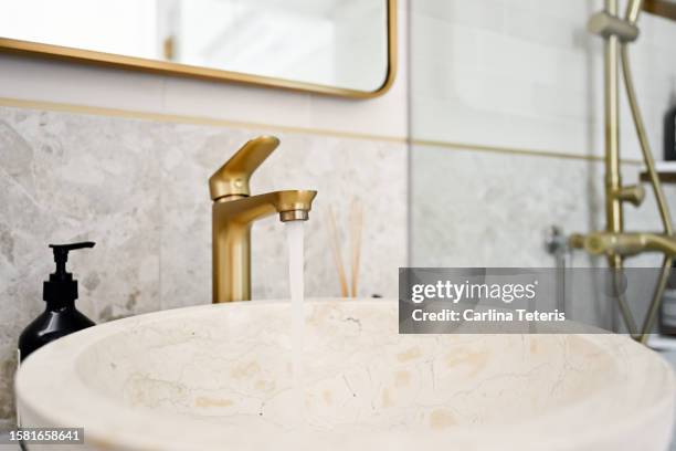 close up of bathroom sink with water running - bathroom closeup stockfoto's en -beelden