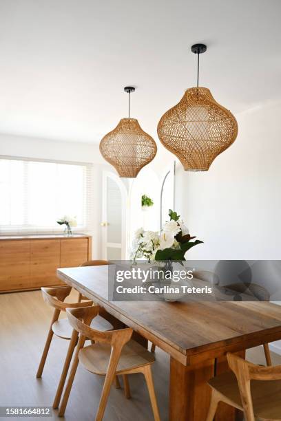 beautiful home dining table with vase of flowers - luz colgante fotografías e imágenes de stock