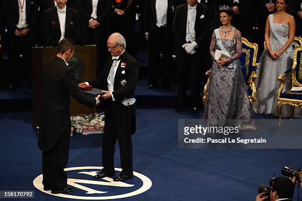 Nobel Prize in Medicine laureate Professor Shinya Yamanaka of Japan receives his Nobel Prize from King Carl XVI Gustaf of Sweden as Queen Silvia of...