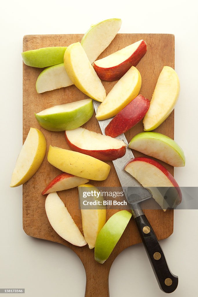Sliced apples on cutting board with knife