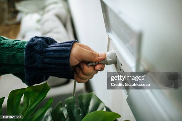 las manos de los hombres están enchufadas en el cargador del cable adaptador de la toma de corriente del teléfono inteligente - panwa thailand fotografías e imágenes de stock