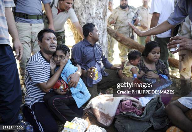 Libyan National Transitional Council fighters provide displaced Bangladeshis with food and drink after fleeing Sirte during heavy fight between...