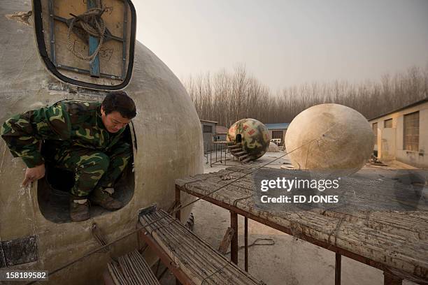 Farmer Liu Qiyuan exits one of seven survival pods that he has also dubbed 'Noah's Arc', in a yard at his home in the village of Qiantun, Hebei...