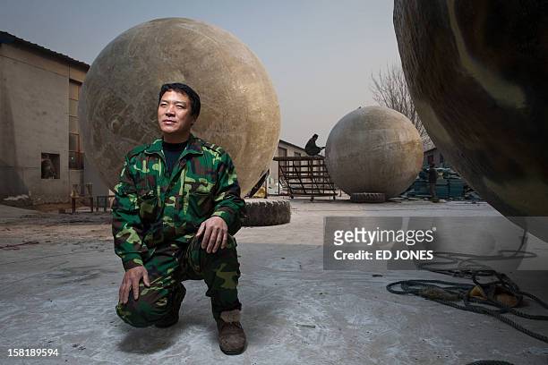 Farmer Liu Qiyuan poses among survival pods that he built and has also dubbed 'Noah's Arc', in a yard at his home in the village of Qiantun, Hebei...