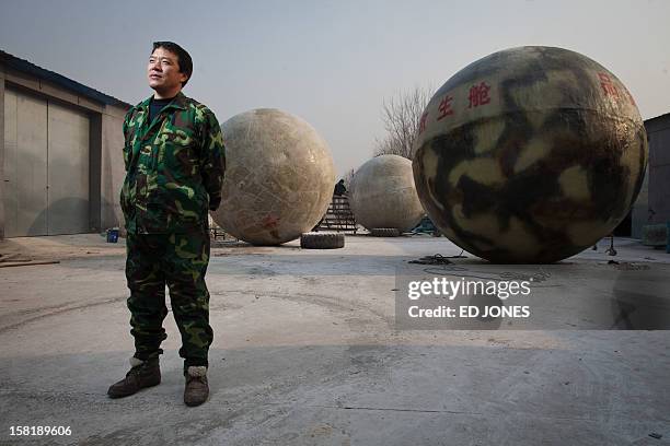 Farmer Liu Qiyuan poses among survival pods that he built and has also dubbed 'Noah's Arc', in a yard at his home in the village of Qiantun, Hebei...