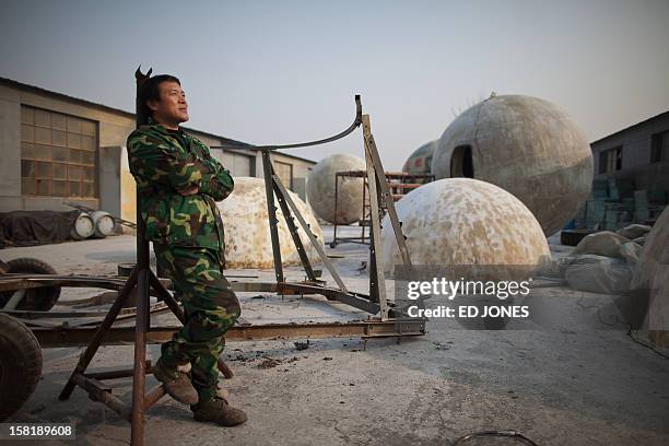 Farmer Liu Qiyuan poses among survival pods that he built and has also dubbed 'Noah's Arc', in a yard at his home in the village of Qiantun, Hebei...