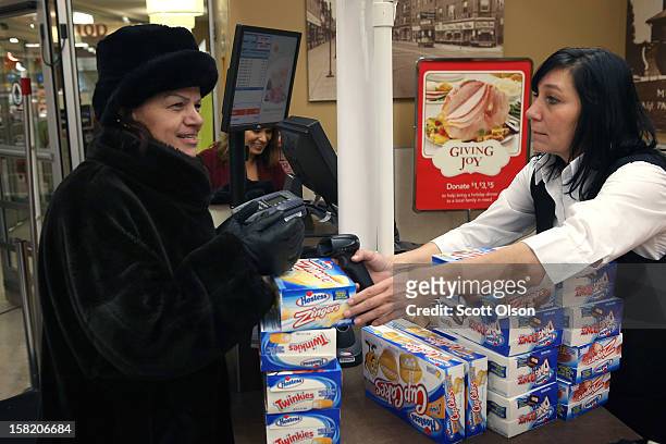 Bini Vedral rings up a Lila Prskalo's purchase of Hostess snacks at a Jewel-Osco grocery store on December 11, 2012 in Chicago, Illinois. The...
