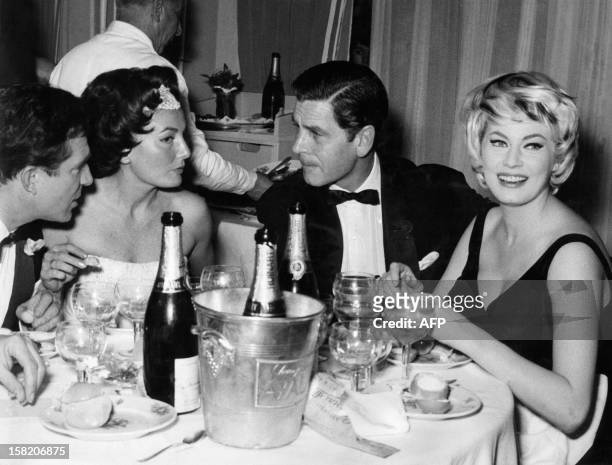 Italian actor Ugo Tognazzi, his fiancee Caprice Chantal, British actor Anthony Steel and his wife, Swedish actress Anita Ekberg, during a diner in...