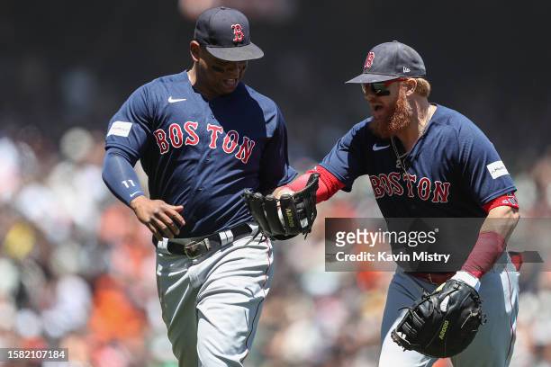 Rafael Devers and Justin Turner of the Boston Red Sox talk as they jog off the field against the San Francisco Giants at the end of the second inning...