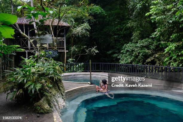 People enjoy thermal spa water sitting around a pool in Termales Beach on January 19, 2023 in Nuqui, Colombia.