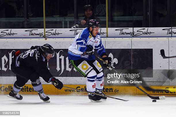 Sebastian Osterloh of Straubing is challenged by Daniel Weiss of Ice Tigers during the DEL match between Thomas Sabo Ice Tigers and Straubing Tigers...