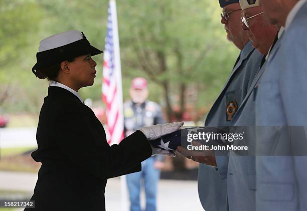 Navy honor guard delivers a folded American flag following a service for Hurricane Sandy victim David Maxwell at the Calverton National Cemetery on...