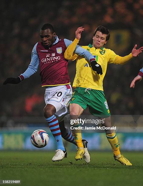 Christian Benteke of Aston Villa battles with Jonny Howson of Norwich City during the Capital One Cup Quarter-Final match between Norwich City and...