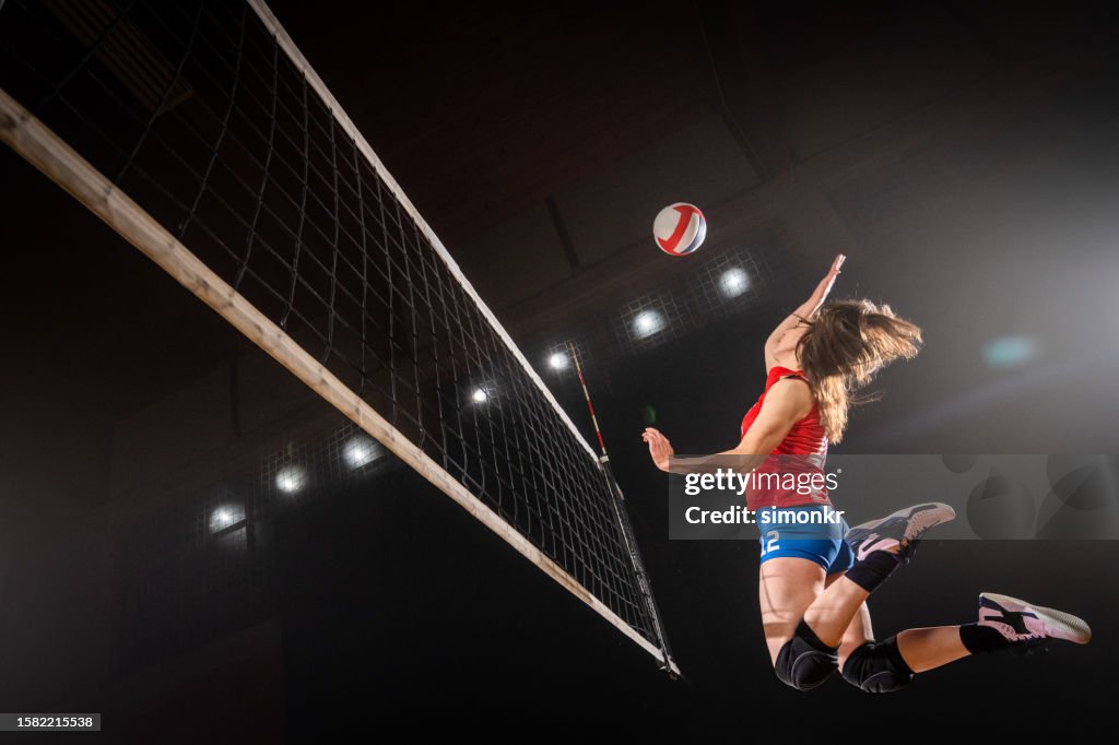 Frau spikt Volleyball