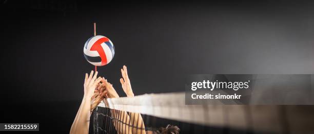 women hands blocking volleyball ball - volleyball competition stock pictures, royalty-free photos & images
