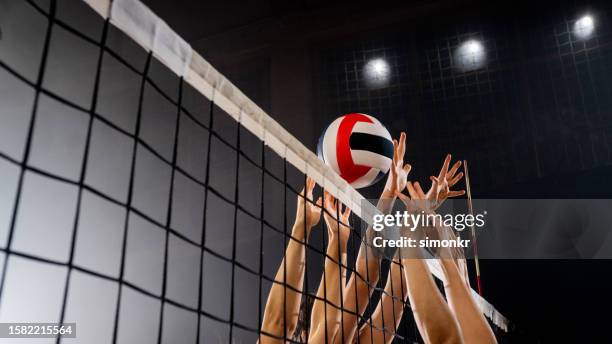 manos femeninas bloqueando pelota de voleibol - juego de vóleibol fotografías e imágenes de stock