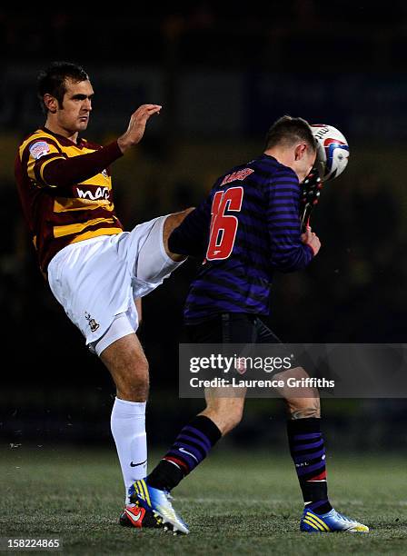 James Hanson of Bradford makes contact with the face of Aaron Ramsey of Arsenal as he attempts to clear the ball during the Capital One Cup quarter...