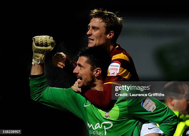 Goalkeeper Matt Duke of Bradford is congratulated by teammate Stephen Darby after saving penalty during the shootout to win the Capital One Cup...