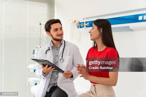 male doctor checking female patient and smiling - handsome doctors stock pictures, royalty-free photos & images