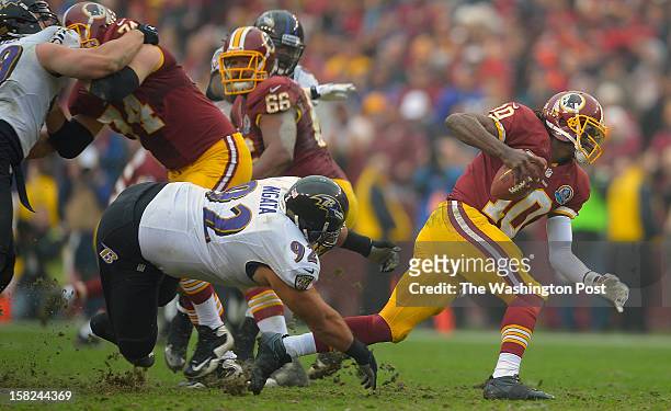 Washington's quarterback Robert Griffin III scrambles out of the way of Baltimore's defensive end Haloti Ngata as the Washington Redskins defeat the...
