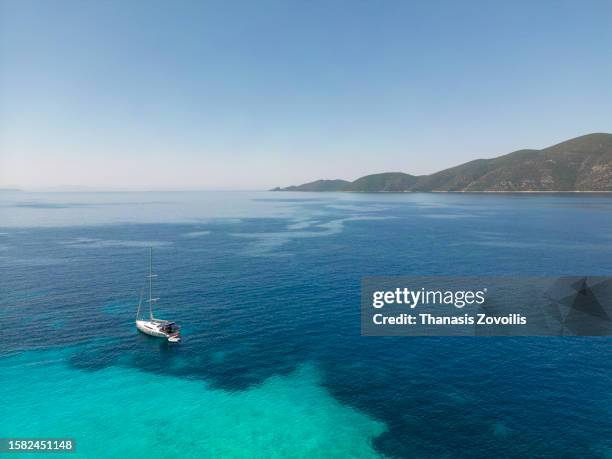 aerial view of sailing yacht in mediterranean sea in porto katsiki, lefkada, greece. - thanasis zovoilis stock pictures, royalty-free photos & images