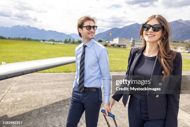 coppia di successo che viaggia con un aereo jet privato - global team foto e immagini stock