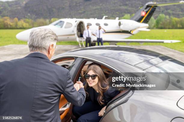 une jeune femme d’affaires sort de sa voiture, prête à monter à bord d’un jet privé - aviation-générale photos et images de collection