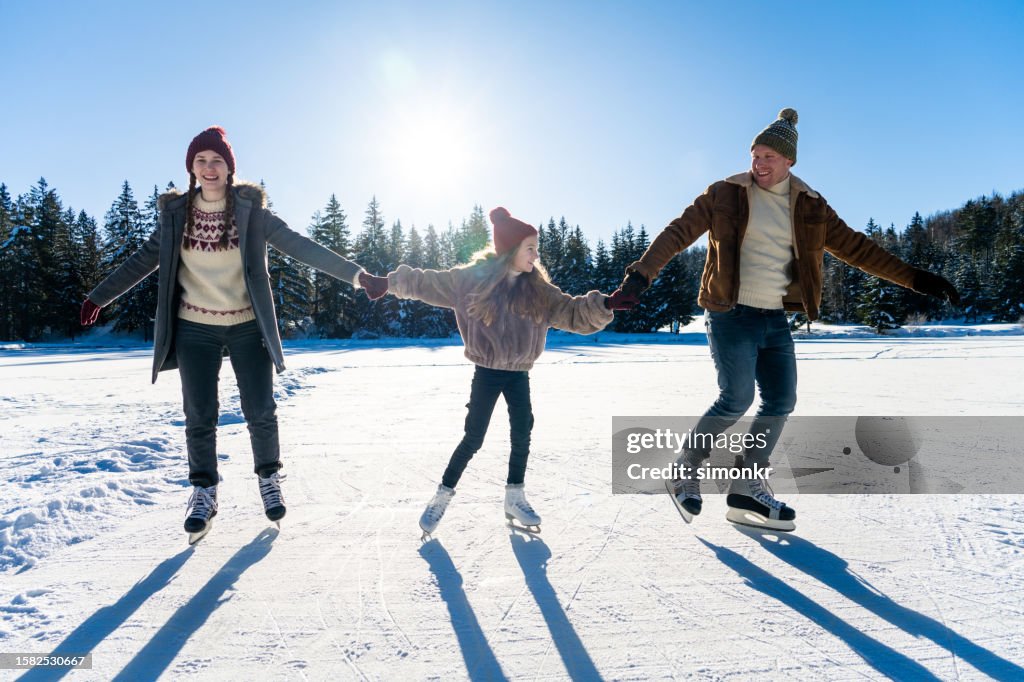 Family ice skating on frozen lake