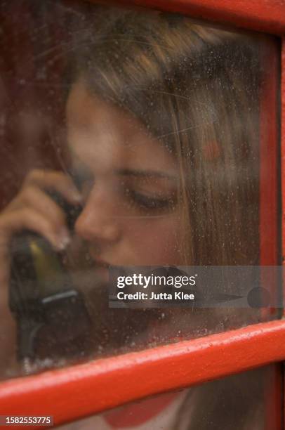 teenaged girl talking on the telephone inside a london phone booth - communication occupation stock pictures, royalty-free photos & images