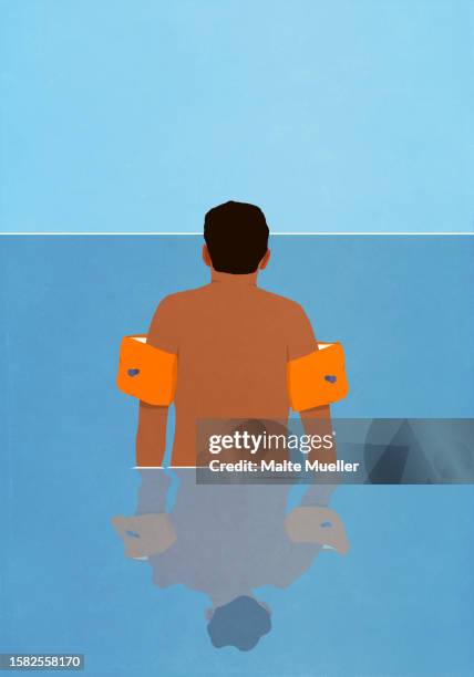 man in water wings wading in ocean water - hüfttief im wasser stock-grafiken, -clipart, -cartoons und -symbole