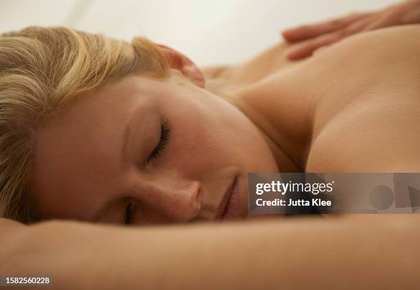 close up of a young woman receiving a back massage - auf dem bauch liegen stock-fotos und bilder