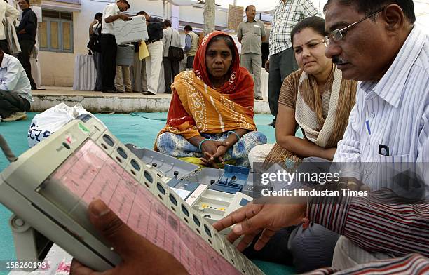 Election duty staffs checking the Electronic Voting Machine before leaving for their respective booths for the first phase of Gujarat assembly...