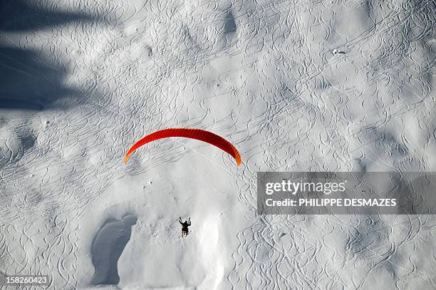 Paraglider glides over Tignes, French Alps, on December 12, 2012. Recent snowfalls have encouraged skiers to hit the slopes and the Tignes...