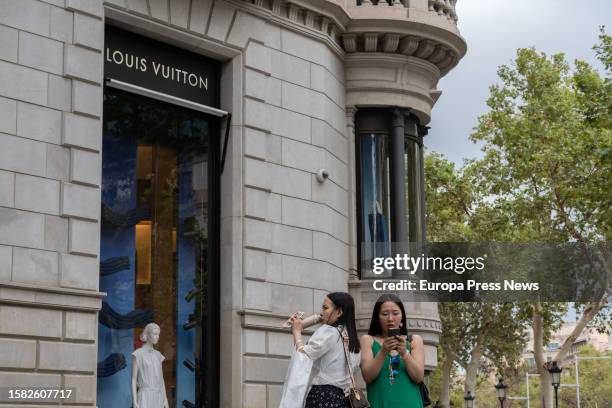 Several people at the entrance of the Louis Vuitton store on