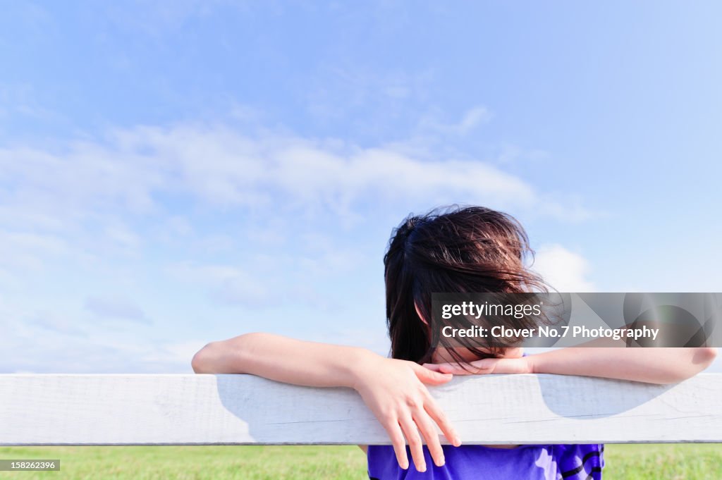 Woman lying on the wooden fence