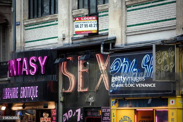 Picture taken on January 12, 2011 in the Paris district of Pigalle, shows the facades of Sex shops with a real estate banner on the top. Banner reads...