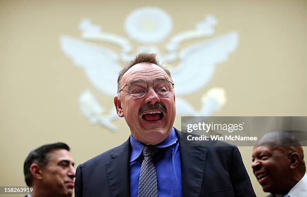 Pro Football Hall of Famer Dick Butkus jokes with Rep. Darrell Issa and Rep. Elijah Cummings prior to testifying before the House Oversight and...