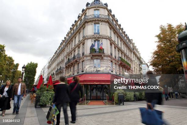 People walk past the Fouquet's restaurant on September 25, 2010 at the Champs-Elysees Avenue in Paris. AFP PHOTO / THOMAS COEX